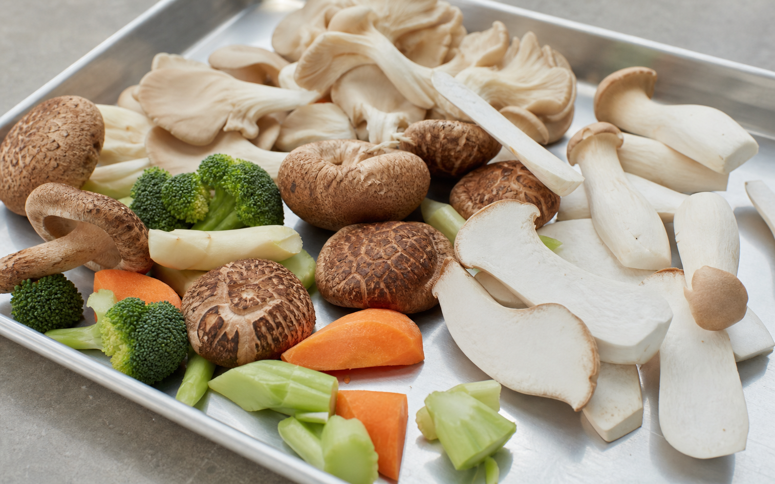 Mushrooms and vegetable ingredients prepared for blanching in food-grade trays